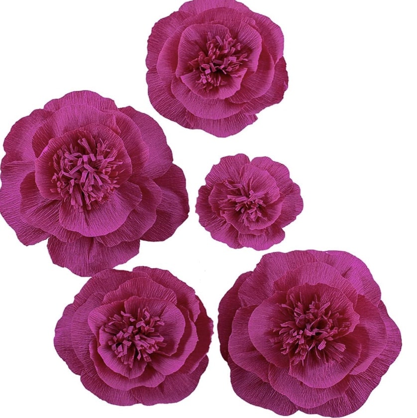 Five vibrant purple paper flowers of varying sizes form a stunning flower garland against a white background. Each handcrafted bloom features layered petals with intricate center details, creating a textured and visually striking display perfect for any DIY project.